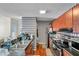 View of kitchen with hardwood floors, diamond pattern wallpaper, stainless steel appliances, and dark countertops at 9481 Highland Oak Dr # 806, Tampa, FL 33647