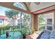 Enclosed lanai with tiled floor, table, and seating, offering an outdoor living space with views of the community at 9481 Highland Oak Dr # 806, Tampa, FL 33647