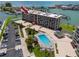 Luxury waterfront condo building featuring a swimming pool, boat docks and beautiful tropical landscaping at 1 Key Capri # 606W, Treasure Island, FL 33706