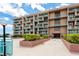 Exterior view of a waterfront condo building featuring private balconies and beautiful landscaping at 1 Key Capri # 606W, Treasure Island, FL 33706