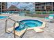 Community hot tub with stone surround, stainless steel handrails, and a poolside relaxing spot at 1 Key Capri # 606W, Treasure Island, FL 33706