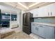 Modern kitchen featuring two-toned cabinets, stainless steel appliances, and a view of the dining area at 1 Key Capri # 606W, Treasure Island, FL 33706