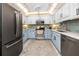 Well-lit kitchen with updated appliances, stylish cabinets, and a view of the dining area at 1 Key Capri # 606W, Treasure Island, FL 33706