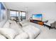 Bright living room with plush white sofa, modern furniture, and sliding glass doors to the balcony at 1 Key Capri # 606W, Treasure Island, FL 33706