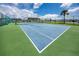 Well-maintained community tennis court surrounded by lush greenery and fencing at 1 Key Capri # 606W, Treasure Island, FL 33706