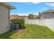 Spacious backyard with lush green grass, privacy fence, and exterior A/C unit at 10021 Brompton Dr, Tampa, FL 33626