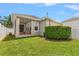Well-manicured backyard with a covered porch, green lawn, and white picket fence at 10021 Brompton Dr, Tampa, FL 33626