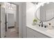 Updated bathroom featuring a modern vanity, round mirror, sleek fixtures, and ample lighting at 10021 Brompton Dr, Tampa, FL 33626