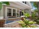 The home's covered porch is cozy, featuring nice seating, plants, and brick support pillars at 10021 Brompton Dr, Tampa, FL 33626