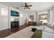 Bright living room with hardwood floors, large windows, modern furniture, and a decorative wall unit at 10021 Brompton Dr, Tampa, FL 33626