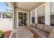 Covered porch with comfortable seating, and a view through the sliding door to the living area at 10021 Brompton Dr, Tampa, FL 33626