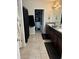 Bathroom with dual sinks, dark wood cabinets, and walk-in closet for storage and organization at 10108 Rosemary Leaf Ln, Riverview, FL 33578