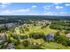An aerial view of a golf course and community surrounded by trees and several ponds and lakes at 11144 Paradise Point Way, New Port Richey, FL 34654
