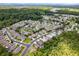 Aerial view showcasing a neighborhood with homes nestled amongst lush trees and multiple ponds, surrounded by greenery at 11144 Paradise Point Way, New Port Richey, FL 34654