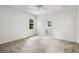 Bright bedroom features a ceiling fan, neutral carpet, and an ensuite bathroom at 11144 Paradise Point Way, New Port Richey, FL 34654