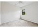 Carpeted bedroom with neutral walls and window overlooking a lush green landscape at 11144 Paradise Point Way, New Port Richey, FL 34654