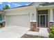 Close-up view of a home's facade, highlighting the two-car garage and decorative stone accents at 11144 Paradise Point Way, New Port Richey, FL 34654