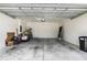 Spacious two-car garage with a concrete floor and ample storage space; includes water heater and garage door opener at 11144 Paradise Point Way, New Port Richey, FL 34654