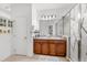 Bathroom featuring double sinks, framed mirrors, ample lighting, and a tiled shower at 11539 Tangle Branch Ln, Gibsonton, FL 33534