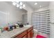 Bathroom with granite counters, wood cabinets, and a shower with striped curtain at 11539 Tangle Branch Ln, Gibsonton, FL 33534