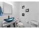 Modern powder room with a blue glass vessel sink, stylish fixtures, and contemporary decor at 11539 Tangle Branch Ln, Gibsonton, FL 33534