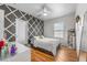 Stylish bedroom with wood floors, a modern gray accent wall, and lots of natural light at 11539 Tangle Branch Ln, Gibsonton, FL 33534