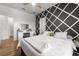 Stylish bedroom featuring gray accent wall, wood-look floors, and lots of natural light at 11539 Tangle Branch Ln, Gibsonton, FL 33534