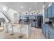Stylish kitchen with stainless steel appliances, a kitchen island with barstool seating, and blue cabinets at 11539 Tangle Branch Ln, Gibsonton, FL 33534