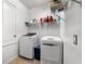 Bright laundry room featuring modern white washer and dryer, with convenient shelving for storage of laundry supplies at 11539 Tangle Branch Ln, Gibsonton, FL 33534