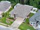 Aerial view of the property showcasing a well-maintained home with a manicured lawn, mature trees, and a two-car garage at 12200 Hunters Lake Dr, New Port Richey, FL 34654