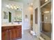 Bathroom with a double vanity, wooden cabinets, tiled floor, and a glass-enclosed shower at 12200 Hunters Lake Dr, New Port Richey, FL 34654