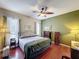 Sunlit bedroom boasts hardwood floors, a ceiling fan, and neutral-toned walls at 12200 Hunters Lake Dr, New Port Richey, FL 34654