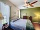 Well-lit bedroom with ceiling fan, hardwood floors, and large windows at 12200 Hunters Lake Dr, New Port Richey, FL 34654