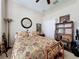 Comfortable bedroom with floral bedding, a ceiling fan, and a bookshelf, creating a relaxed atmosphere at 12200 Hunters Lake Dr, New Port Richey, FL 34654