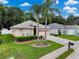 A charming single-story home featuring an attached two-car garage, complemented by a lush lawn and mature palm trees at 12200 Hunters Lake Dr, New Port Richey, FL 34654