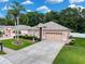 Beautiful home with well-kept lawn, mature landscaping, and an attached two-car garage, plus lush green space at 12200 Hunters Lake Dr, New Port Richey, FL 34654