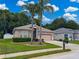 Charming single-story home featuring a well-manicured lawn, mature palm trees, and a cozy front entrance with great curb appeal at 12200 Hunters Lake Dr, New Port Richey, FL 34654