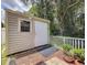 Backyard shed with a window and door, nestled amongst greenery with brick base at 12200 Hunters Lake Dr, New Port Richey, FL 34654
