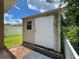 Tan vinyl shed with a large front door and window adding storage space to the backyard at 12200 Hunters Lake Dr, New Port Richey, FL 34654