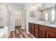 Bathroom featuring wood cabinets, double vanity, walk-in shower, and walk-in closet at 12322 Eagle Swoop Pl, Riverview, FL 33579