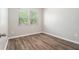 Bright bedroom with wood-look flooring and two windows with natural light at 12322 Eagle Swoop Pl, Riverview, FL 33579