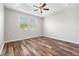 Neutral bedroom with tray ceiling, ceiling fan, and wood-look flooring at 12322 Eagle Swoop Pl, Riverview, FL 33579