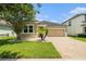 Charming single-Gathering home featuring a brick driveway, two-car garage, and mature landscaping at 12322 Eagle Swoop Pl, Riverview, FL 33579