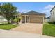 Charming single-Gathering home featuring a brick driveway, two-car garage, and mature landscaping at 12322 Eagle Swoop Pl, Riverview, FL 33579