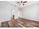 Spacious primary bedroom featuring tray ceiling, ceiling fan, and wood-look flooring at 12322 Eagle Swoop Pl, Riverview, FL 33579