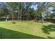 Spacious backyard featuring lush green grass, mature trees, and a black fence at 12333 Harris Hawk Rd, Weeki Wachee, FL 34614