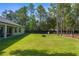 Spacious backyard with lush green grass, bordered by tall trees and fencing at 12333 Harris Hawk Rd, Weeki Wachee, FL 34614