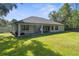 Rear elevation of home with a spacious lawn, patio area, and lawn equipment at 12333 Harris Hawk Rd, Weeki Wachee, FL 34614