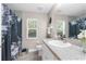 Well-lit bathroom features granite countertops and a floral-themed shower curtain at 12333 Harris Hawk Rd, Weeki Wachee, FL 34614
