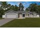 Beautiful single-Gathering home featuring a manicured lawn, two-car garage and a welcoming entrance at 12333 Harris Hawk Rd, Weeki Wachee, FL 34614